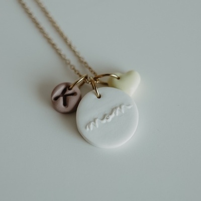 Colar dourado com três pendentes variados em branco, amarelo e roxo