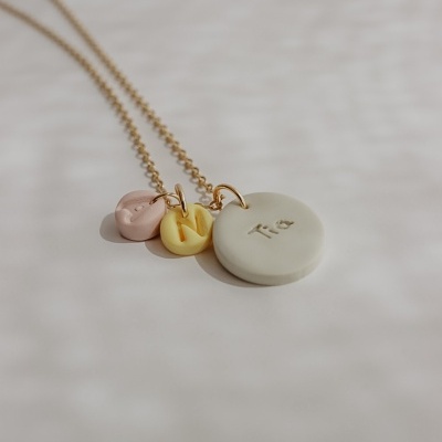 Colar com três pendentes redondos em tons pastel e corrente dourada