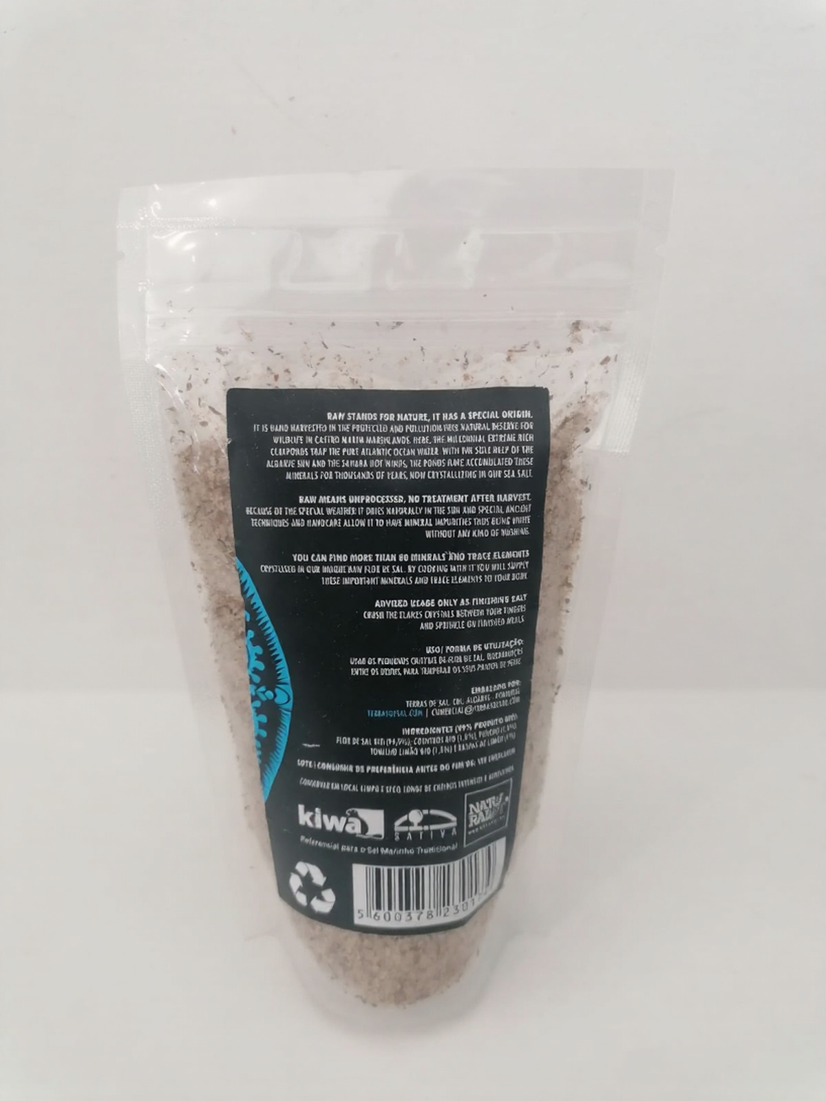 Flor de Sal - Mistura cítrica para peixe Saco transparente com sal marinho grosso e etiqueta preta com texto, código de barras e logótipos.