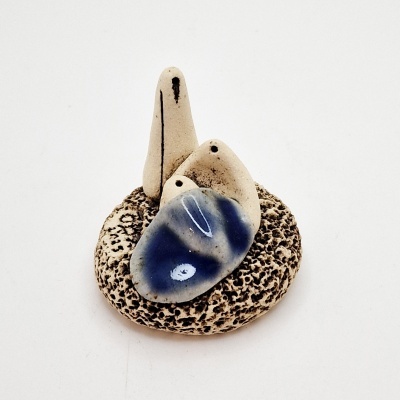 Escultura em cerâmica com base circular bege e três formas verticais distintas