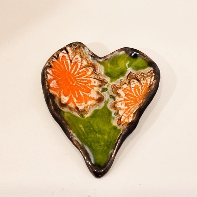 Broche cerâmico em forma de coração com flores coloridas
