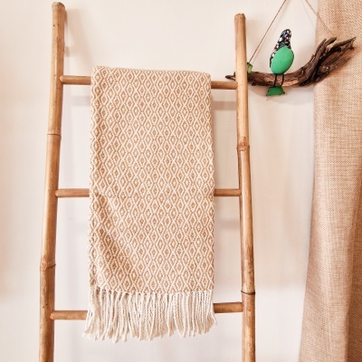 Escada de madeira com toalha bege de padrão geométrico pendurada