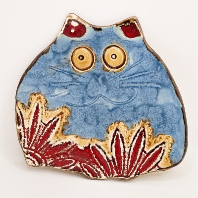 Figura decorativa de cerâmica em forma de gato azul com detalhes vermelhos e amarelos