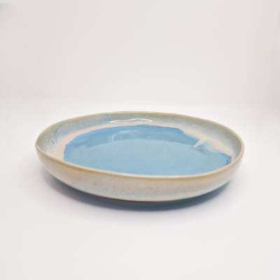 Prato redondo em cerâmica azul e bege com acabamento vidrado