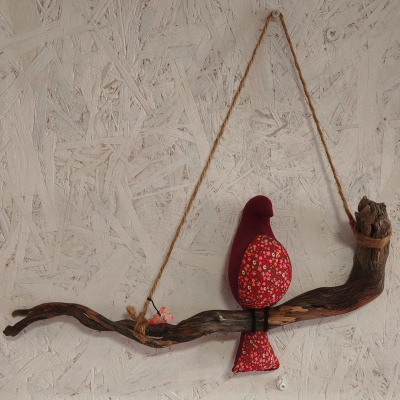 Decoração artesanal de parede com pássaro de tecido vermelho e galho de madeira escura