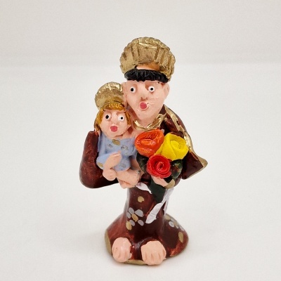Figura cerâmica casal com filho e flores coloridas em fundo branco