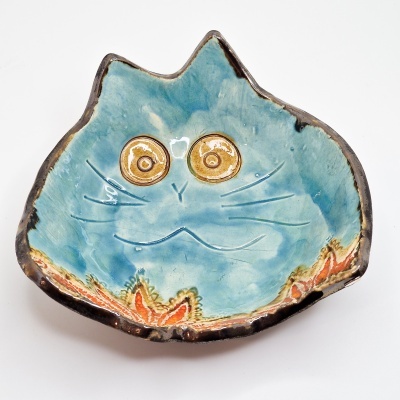 Prato de cerâmica azul em forma de cabeça de gato com olhos amarelos