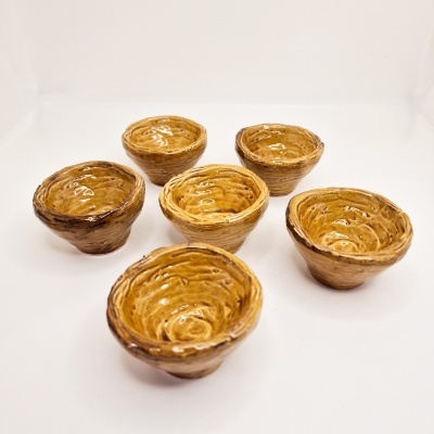 Seis tigelas cerâmicas castanhas vidradas em superfície branca