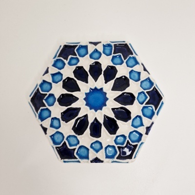 Azulejo hexagonal azul com padrão geométrico em fundo branco