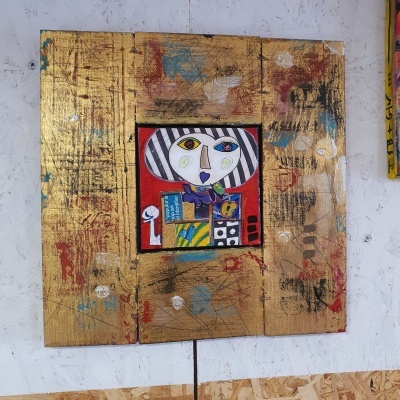 Quadro com rosto estilizado colorido e moldura dourada envelhecida