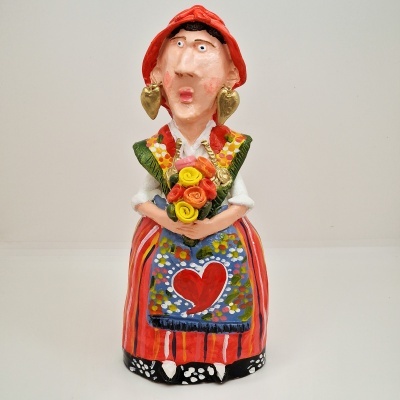 Estatueta colorida de mulher com traje tradicional e ramo de flores