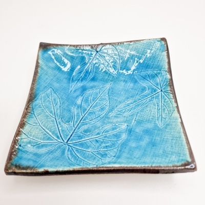 Prato quadrado azul de cerâmica com padrão de folhas em relevo