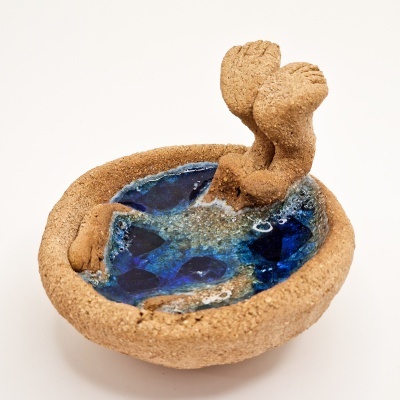 Escultura cerâmica de piscina com pernas humanas a mergulhar