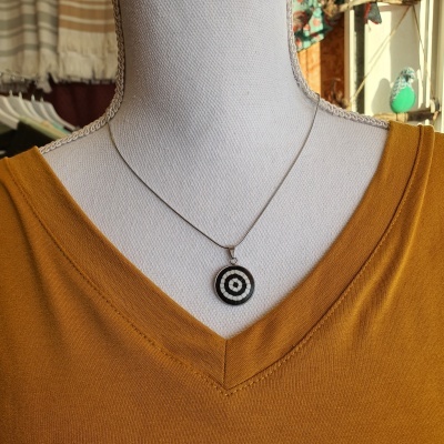 Colar com pendente redondo preto e branco em manequim com blusa amarelo mostarda