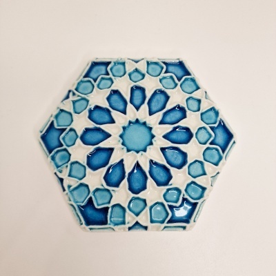 Azulejo cerâmico hexagonal azul e branco com padrão geométrico