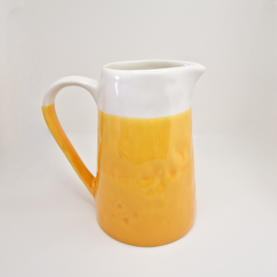 Jarro de cerâmica branco e amarelo com bico vertedor e alça