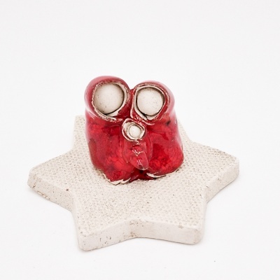 Par de botas vermelhas de cerâmica sobre base estrela branca