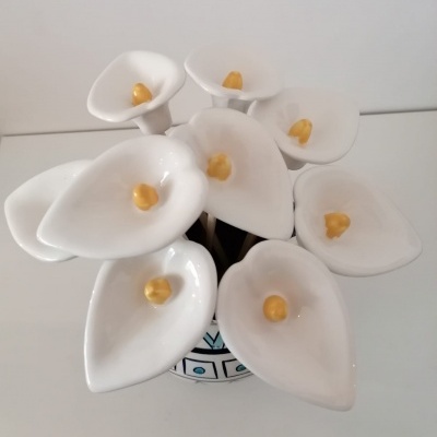 Buquê cerâmico de flores brancas com pistilos amarelos num vaso pequeno decorado