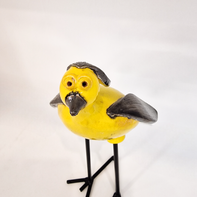 Estatueta de pássaro amarelo e preto em suporte metálico