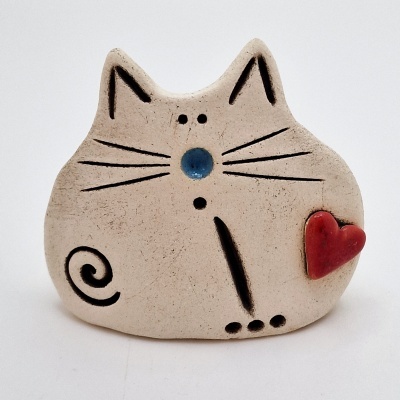 Escultura de gato em cerâmica bege com detalhes pretos e coração vermelho