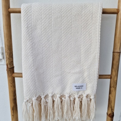 Manta creme em algodão pendurada numa escada de madeira