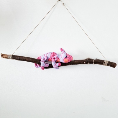 Decoração pendurada com ramo de madeira e camaleão de tecido cor-de-rosa