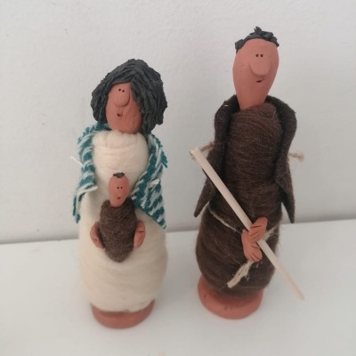 Figuras de presépio artesanais em barro e lã, incluindo mulher, bebé e homem com cajado