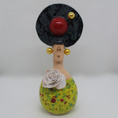 Figura decorativa de cerâmica com vestido amarelo, flor branca, chapéu preto e botão vermelho