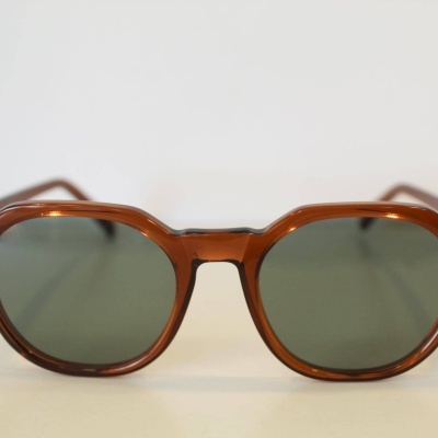 Óculos de sol castanhos com lentes verdes escuras e armação em plástico.