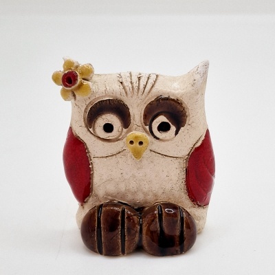 Figura decorativa de coruja em cerâmica com asas vermelhas e flor na cabeça