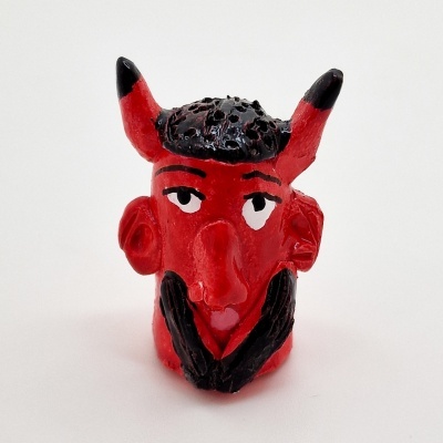 Figura decorativa vermelha com chifres e barba preta
