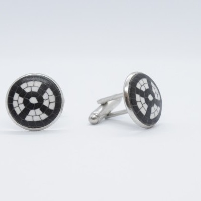 Botões de punho redondos em metal prateado com padrão geométrico preto e branco.