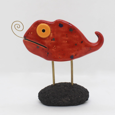 Objeto decorativo em forma de peixe vermelho com base preta rugosa