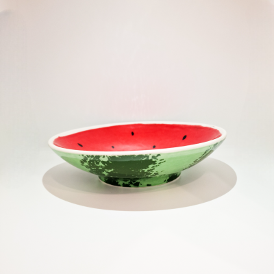 Prato cerâmico com padrão de melancia, vermelho e verde, sobre superfície branca