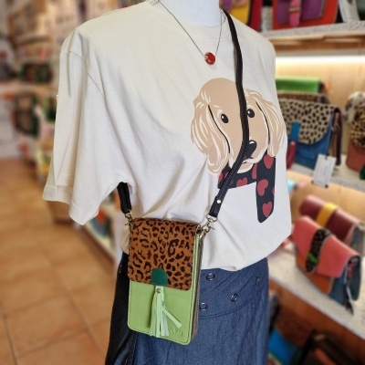 T-shirt branca com estampa de cão, saia azul e bolsa pequena com padrão leopardo e verde claro