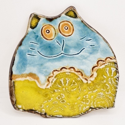 Peça decorativa em cerâmica de gato azul e amarelo com olhos castanhos