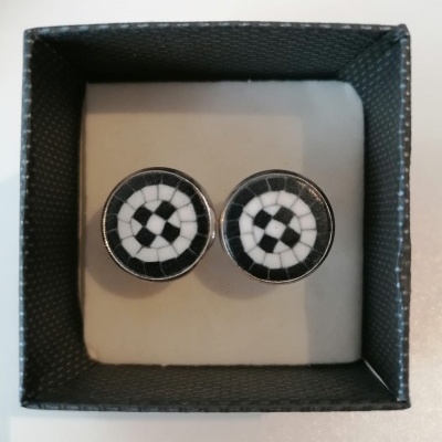 Botões de punho redondos preto e branco com padrão circular em caixa preta.