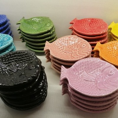 Peças cerâmicas em forma de peixe coloridas empilhadas