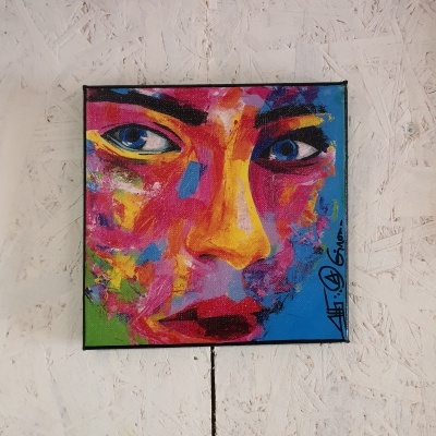 Quadro colorido de rosto feminino abstrato sobre parede clara