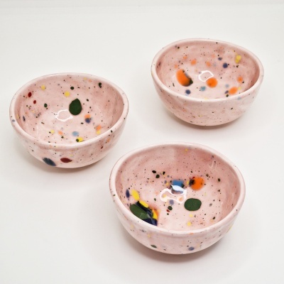 Três tigelas pequenas de cerâmica rosa com manchas coloridas