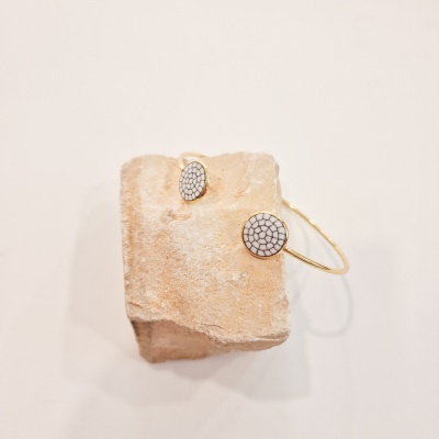 Conjunto de anel e pulseira dourados com padrão celular branco e preto em pedra bege