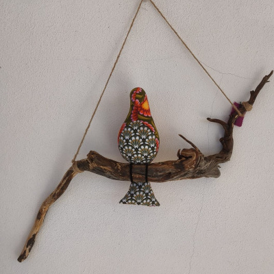 Pássaro decorativo de madeira pintada em galho natural pendurado na parede