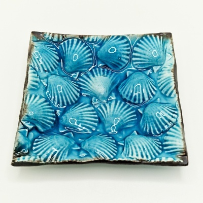 Prato quadrado azul com padrão de conchas em relevo
