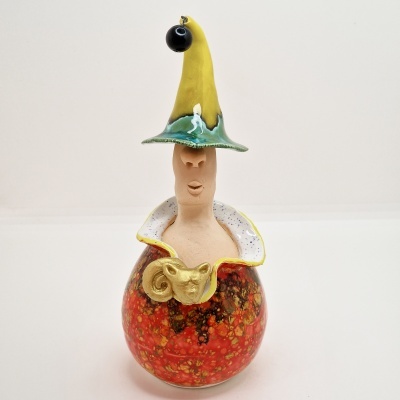 Escultura decorativa em cerâmica com base vermelha e preta e chapéu amarelo