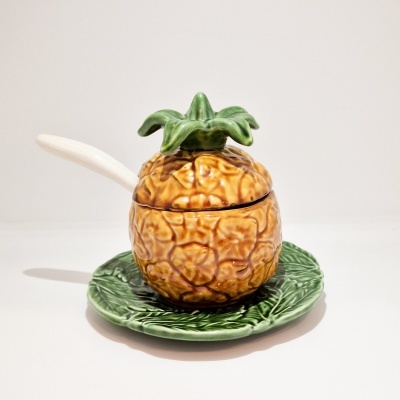 Conjunto cerâmico com tigela em forma de ananás, colher branca e prato verde com textura de folhas