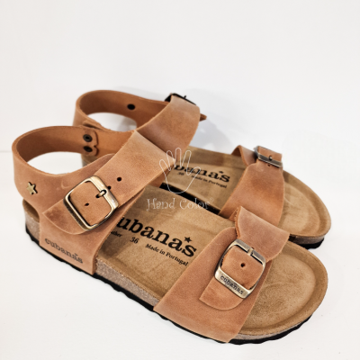 Sandálias castanhas tipo camurça com fivelas metálicas douradas e sola preta.