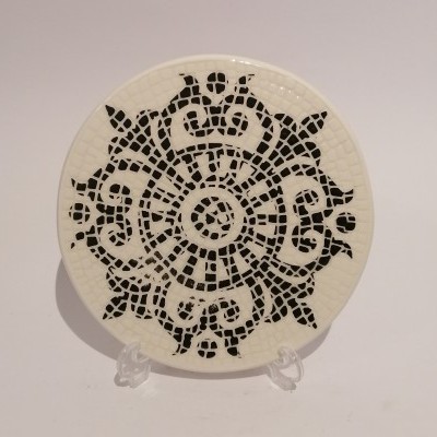 Prato redondo com padrão mosaico preto e branco num suporte transparente
