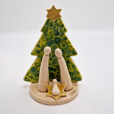 Presépio cerâmico com três figuras e árvore de Natal verde com estrela