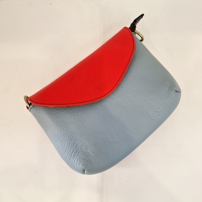 Mala pequena azul claro e vermelha em couro com textura
