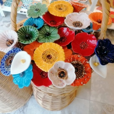 Cesto de vime com flores decorativas coloridas em cerâmica